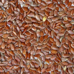 Brown flaxseed on light background